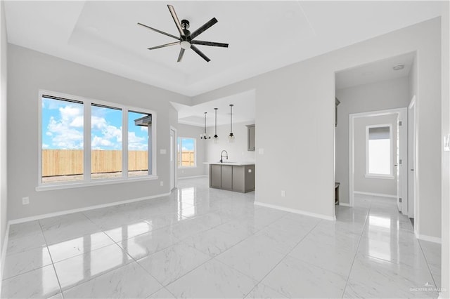341 Leon Ave, Elsa, TX 78543 - unfurnished living room with a raised ceiling, light marble finish flooring, and ceiling fan