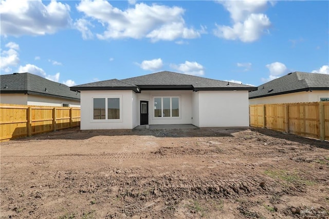 341 Leon Ave, Elsa, TX 78543 - rear view of property featuring a fenced backyard, stucco siding, and roof with shingles