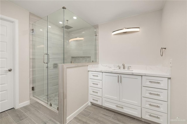 bathroom with vanity, a stall shower, and wood finish floors