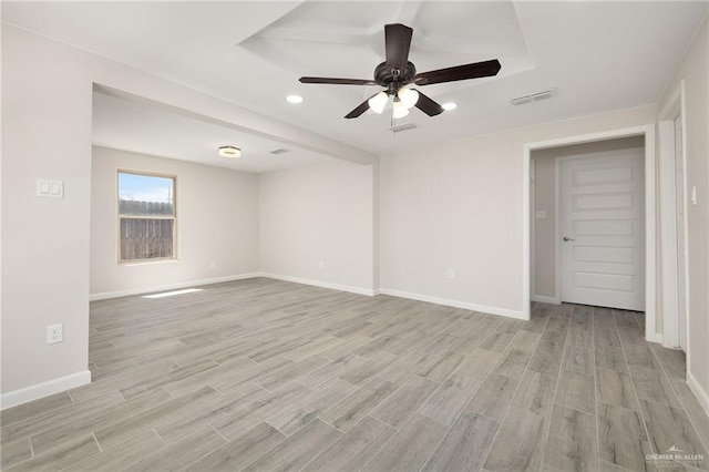 empty room with light wood-style flooring, baseboards, and visible vents