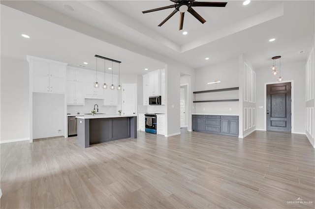 unfurnished living room featuring a ceiling fan, a sink, recessed lighting, light wood finished floors, and baseboards
