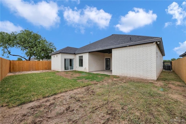 rear view of property featuring brick siding, a patio area, cooling unit, and roof with shingles