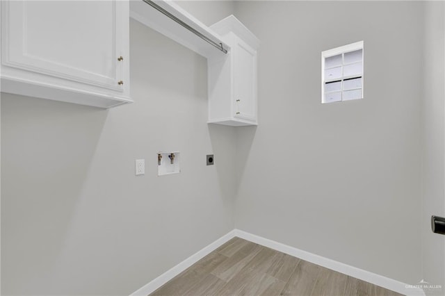 clothes washing area featuring electric dryer hookup, cabinet space, hookup for a washing machine, light wood finished floors, and baseboards