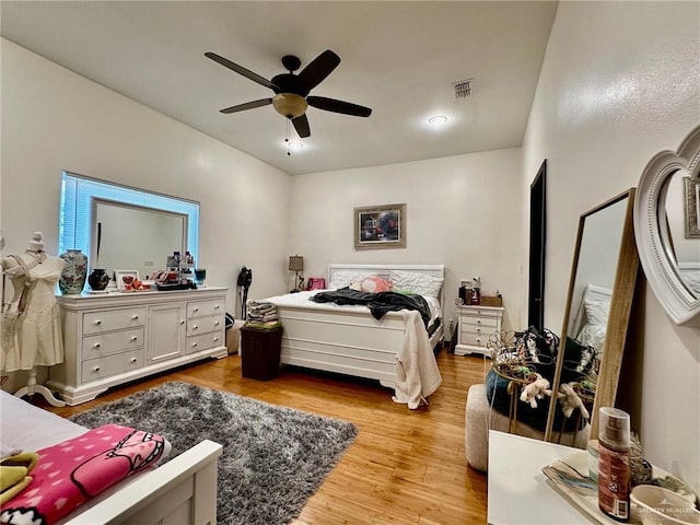 bedroom featuring wood finished floors, visible vents, and a ceiling fan