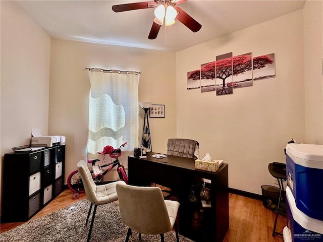 office space with light wood finished floors, baseboards, and a ceiling fan