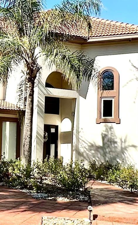 doorway to property with a tile roof and stucco siding