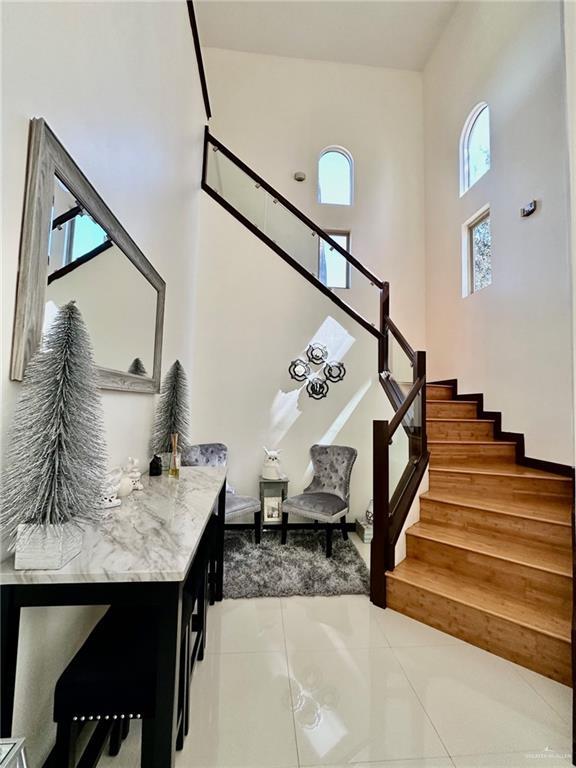 stairs with tile patterned flooring and a high ceiling