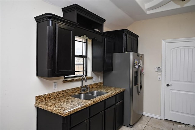 kitchen featuring light tile patterned flooring, stainless steel refrigerator with ice dispenser, lofted ceiling, and sink