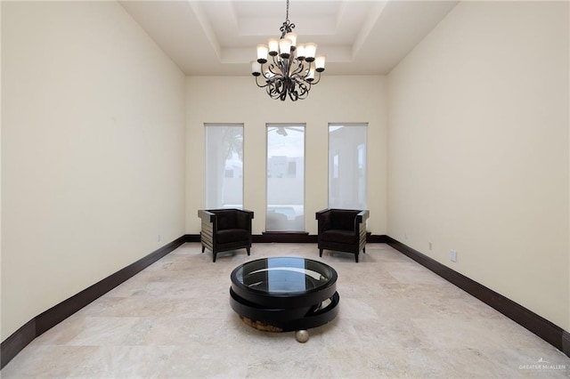 sitting room featuring a notable chandelier and a raised ceiling