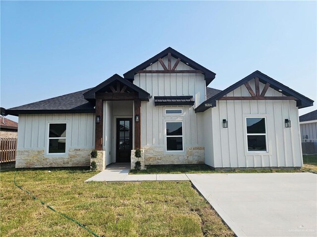 1604 Matilda Rose St, Weslaco, TX 78599 - view of front of home with board and batten siding, stone siding, and a shingled roof