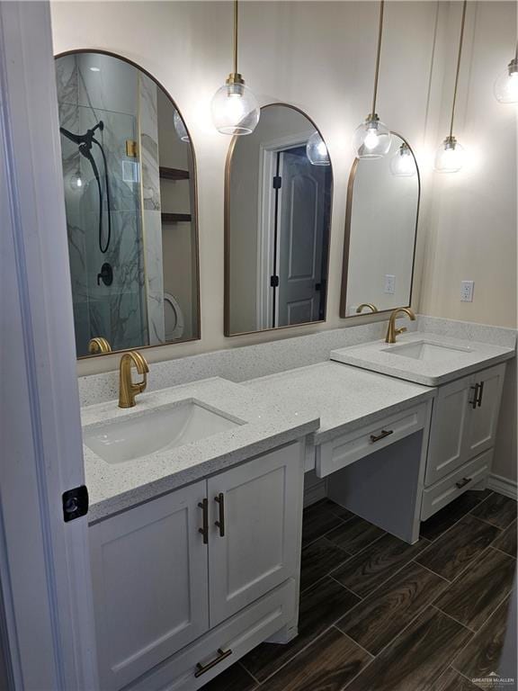 1604 Matilda Rose St, Weslaco, TX 78599 - bathroom featuring a marble finish shower, wood tiled floors, and double vanity