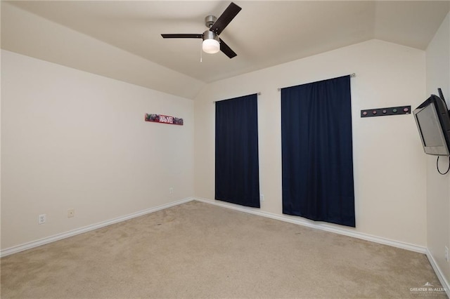 spare room featuring ceiling fan, vaulted ceiling, and light carpet