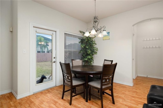 dining space with a chandelier and light hardwood / wood-style flooring