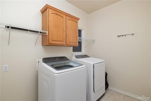 laundry area featuring cabinets, washing machine and clothes dryer, and light tile patterned flooring