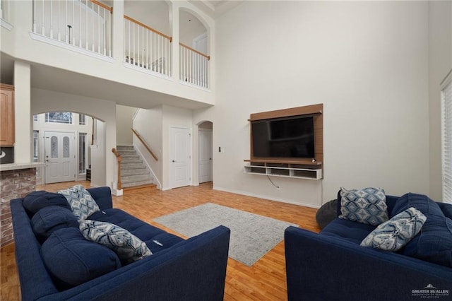 living room featuring a high ceiling and light hardwood / wood-style floors