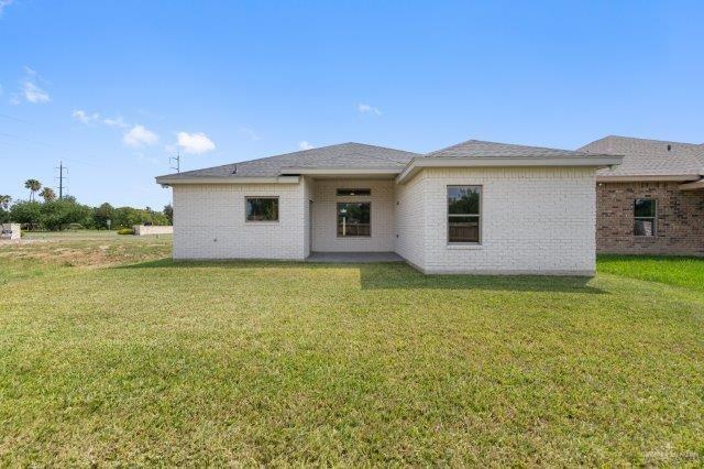 1212 Bridle Way, San Benito, TX 78586 - back of property featuring a yard and brick siding