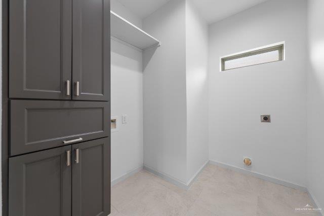 1212 Bridle Way, San Benito, TX 78586 - laundry area featuring hookup for an electric dryer, cabinet space, and baseboards