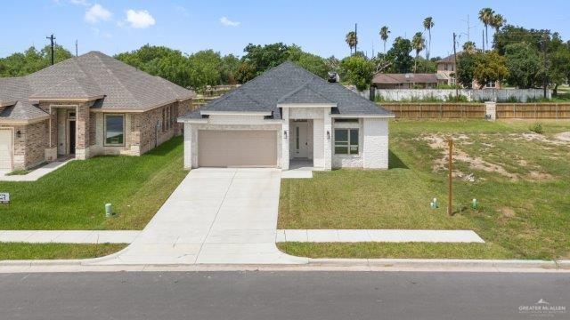 1212 Bridle Way, San Benito, TX 78586 - view of front facade with concrete driveway, a front lawn, and an attached garage