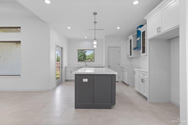 1212 Bridle Way, San Benito, TX 78586 - kitchen featuring light countertops, a sink, a center island, recessed lighting, and white cabinetry