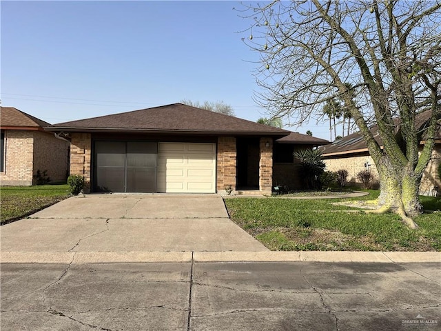 view of front of house featuring brick siding, a shingled roof, a front lawn, concrete driveway, and an attached garage