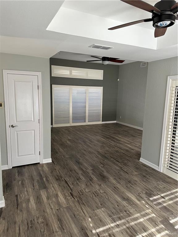 spare room featuring baseboards, wood finished floors, visible vents, and ceiling fan