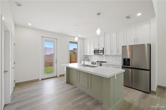 1218 N Lincoln Ave, San Juan, TX 78589 - kitchen featuring stainless steel appliances, a sink, white cabinets, decorative backsplash, and light countertops