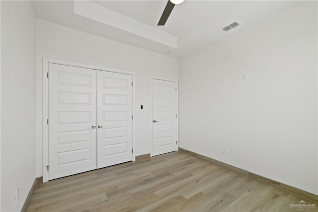 1218 N Lincoln Ave, San Juan, TX 78589 - unfurnished bedroom with light wood-style flooring, a closet, a raised ceiling, and baseboards