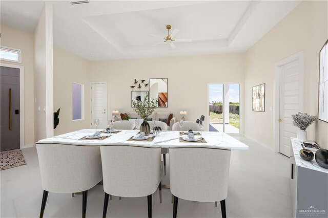 dining room with elevator, a raised ceiling, and plenty of natural light