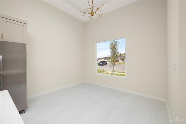 unfurnished dining area with baseboards and an inviting chandelier