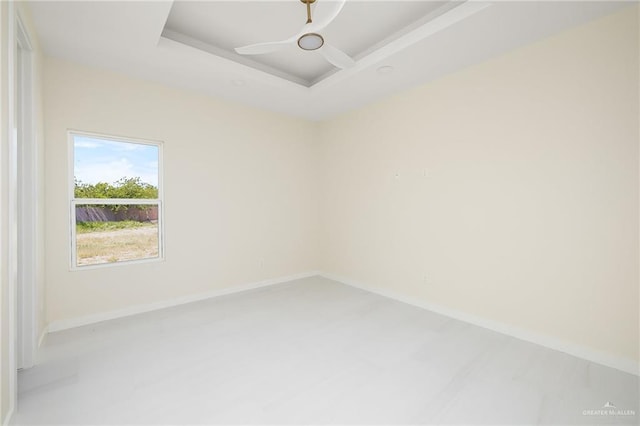 spare room featuring baseboards and a tray ceiling