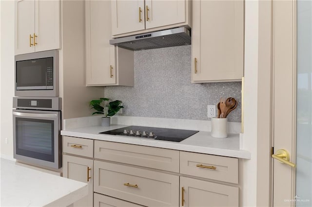 kitchen featuring under cabinet range hood, oven, built in microwave, and light countertops