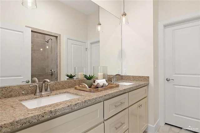 bathroom with a tile shower and vanity