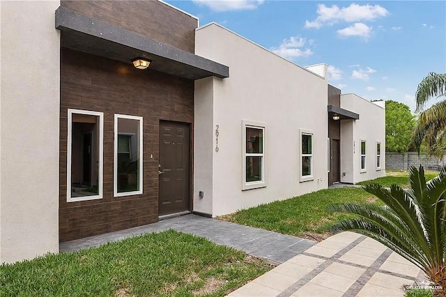 entrance to property with a lawn