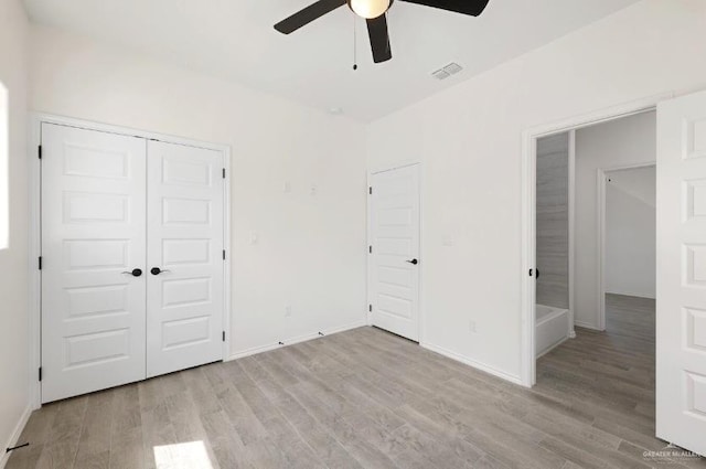 unfurnished bedroom featuring ceiling fan, a closet, and light hardwood / wood-style floors