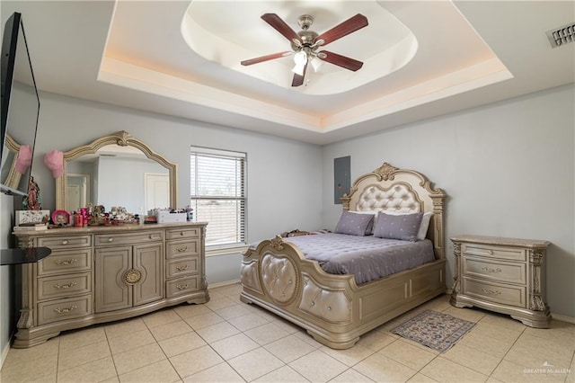 bedroom featuring light tile patterned floors, a tray ceiling, visible vents, and baseboards