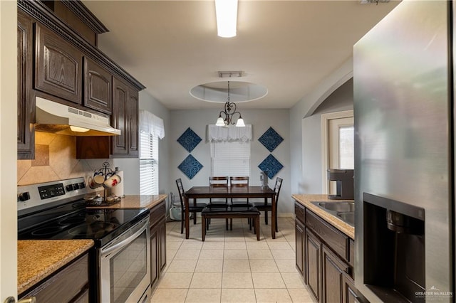 kitchen with light tile patterned floors, tasteful backsplash, appliances with stainless steel finishes, dark brown cabinets, and under cabinet range hood