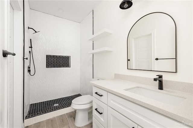 bathroom with a shower, hardwood / wood-style floors, vanity, and toilet