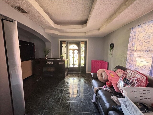 7221 S San Joaquin St, Pharr, TX 78577 - foyer with visible vents, baseboards, a tray ceiling, and a textured ceiling