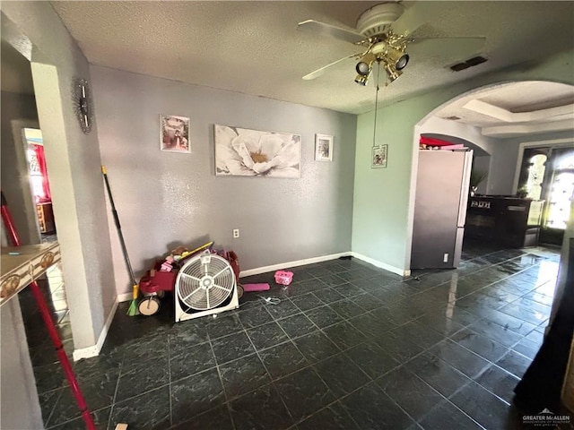 7221 S San Joaquin St, Pharr, TX 78577 - rec room with arched walkways, baseboards, a ceiling fan, and a textured ceiling