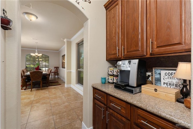 4230 Stillwater Cv, Edinburg, TX 78542 - kitchen featuring arched walkways, baseboards, a chandelier, crown molding, and light tile patterned floors