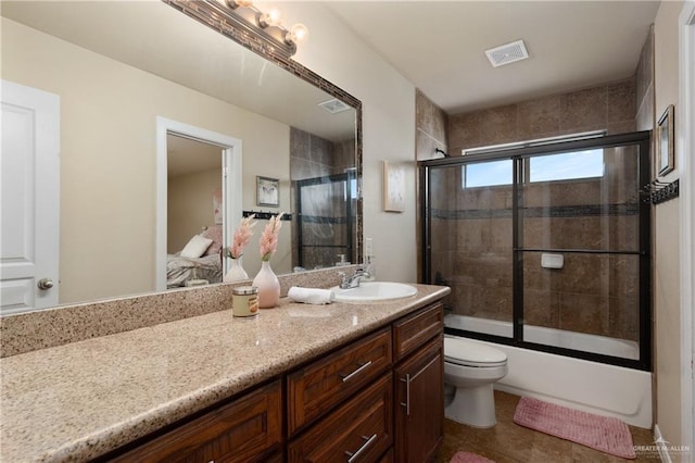 4230 Stillwater Cv, Edinburg, TX 78542 - bathroom featuring visible vents, toilet, vanity, and bath / shower combo with glass door