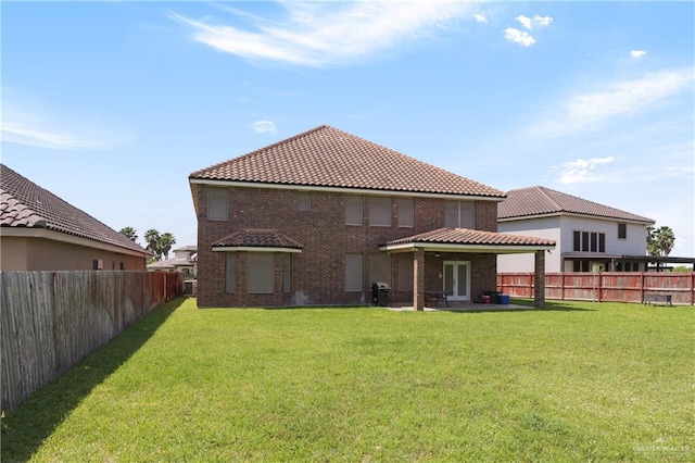 4230 Stillwater Cv, Edinburg, TX 78542 - rear view of property with a lawn, brick siding, a tiled roof, and a fenced backyard