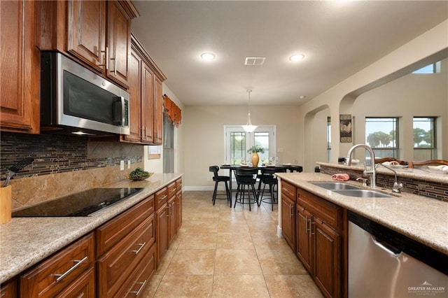 4230 Stillwater Cv, Edinburg, TX 78542 - kitchen with arched walkways, a sink, visible vents, decorative backsplash, and appliances with stainless steel finishes