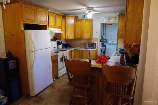 kitchen with light tile patterned flooring, sink, an inviting chandelier, and a kitchen breakfast bar