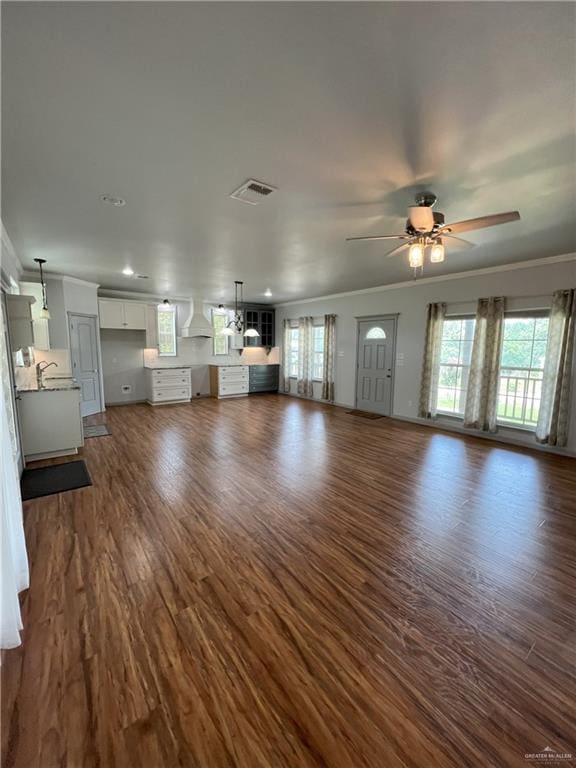 119 Cherokee Cir, Smithville, TX 78957 - unfurnished living room with ceiling fan, ornamental molding, plenty of natural light, dark wood finished floors, and recessed lighting