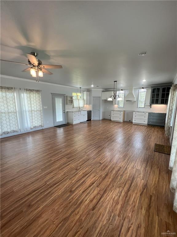 119 Cherokee Cir, Smithville, TX 78957 - unfurnished living room with dark wood finished floors, a ceiling fan, crown molding, and recessed lighting