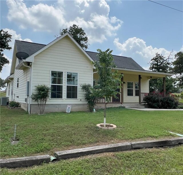 119 Cherokee Cir, Smithville, TX 78957 - rear view of house featuring a lawn, central AC, and covered porch