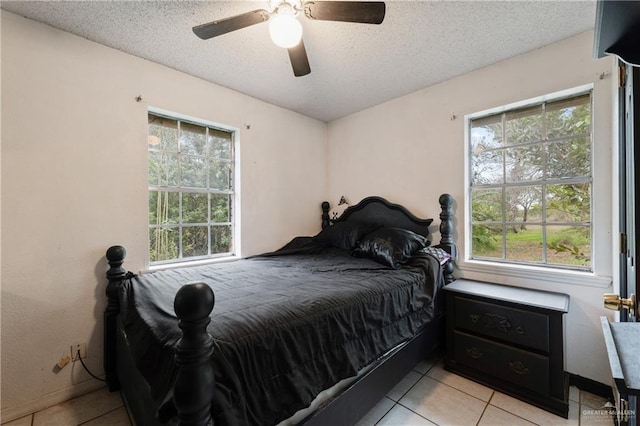 tiled bedroom featuring multiple windows, a textured ceiling, and ceiling fan