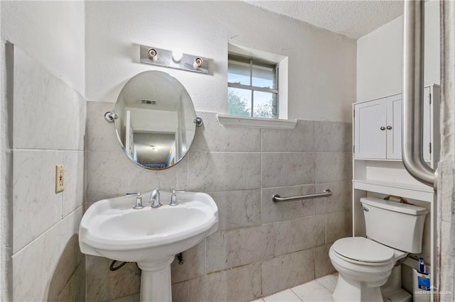 bathroom with tile patterned floors, a textured ceiling, and toilet