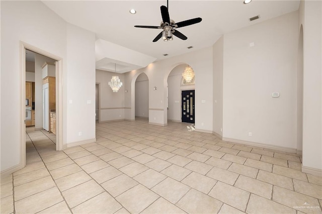 unfurnished room featuring ceiling fan with notable chandelier and light tile patterned floors